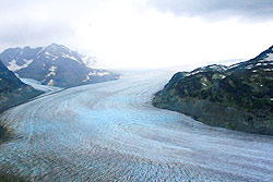 Photo courtesy of Debra Austin. A wide blue glacier full of crevices flows toward the valley below.