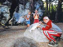 Three children show off their fish catch in Bella Coola.