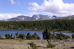 Photo property of Miriam Schilling. Blue alpine lake with rimrock mountain behind it.