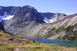 Photo property of Miriam Schilling. A blue green glacier fed lake below mountain peaks.