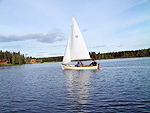 Home made sail boat with three people in it on Nimpo Lake.