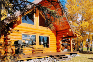 Large log cabin with deck and view of Nimpo Lake in front. A newer built and very large, comfortable cabin with loft windows.