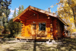 Smaller Pioneer built log cabin with deck. Cozy but airy little cabin with a deck.